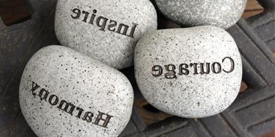 3 stones with words carved in, on a metal crate